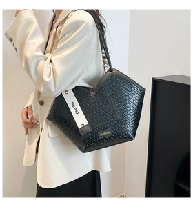 Détail d'un grand cabas noir avec texture et large bandoulière blanche imprimée