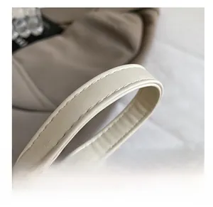 Close-up of cream white shoulder strap with fine stitching and soft leather texture