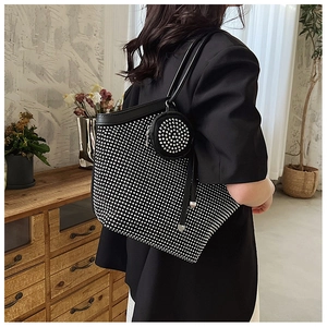 Detail of black rhinestone tote bag with matching round coin purse on shoulder