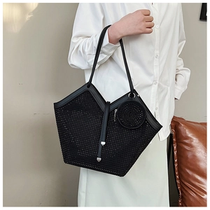 Detail of black rhinestone tote bag showing shiny texture and small hanging round pouch