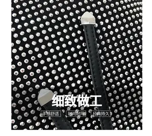 Close-up of sparkling rhinestones on black leather tote bag with silver metal tips