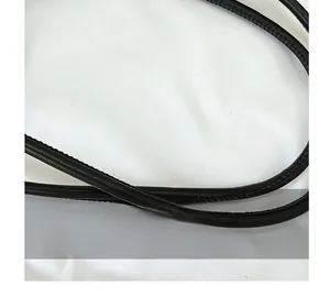 Detail of black leather shoulder strap with fine stitching and soft pebbled texture