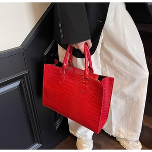 Close-up of red crocodile pattern tote bag with dual handles for stylish commuting