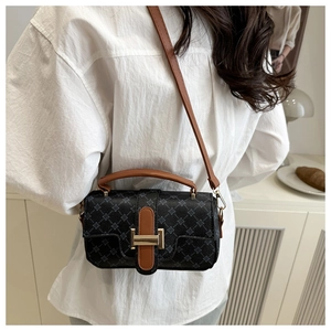Macro shot of vintage patterned crossbody bag with brown leather strap and gold buckle