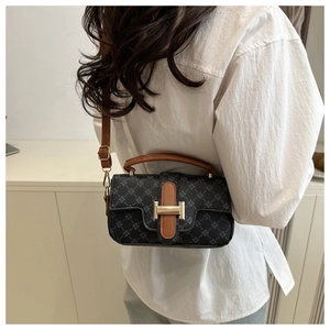 Detail of printed crossbody bag with golden H-buckle and leather strap on model