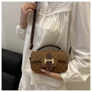 Detail of vintage brown printed crossbody bag with gold hardware and H-shaped buckle