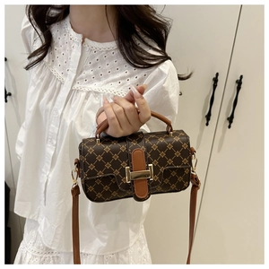 Detail of vintage patterned crossbody bag with gold buckle and leather shoulder strap