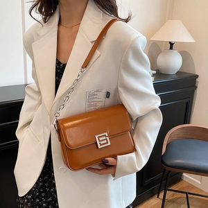 Vintage brown leather underarm bag with silver S-shaped buckle and chain strap