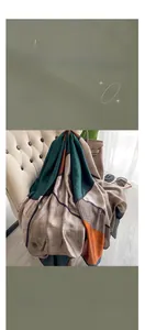 Detail of satin scarf with geometric color blocks and houndstooth pattern on leather chair