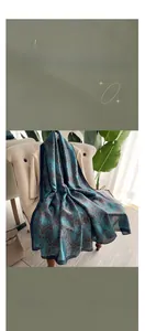 Detail of blue and green paisley silk scarf draped over a chair in a luxury setting