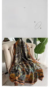 Detail of silk satin scarf with vintage paisley and tropical floral patterns on a sofa