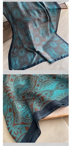 Detail showing teal paisley pattern on dark brown silk scarf with rich texture