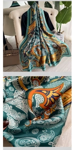Detailed macro view of vintage paisley patterns on a silky teal and orange scarf shawl