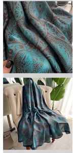 Detailed close-up of blue totem paisley printed silk shawl on a beige sofa