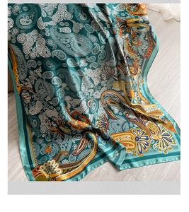 Close-up of silk texture shawl with vintage paisley patterns in deep teal and orange