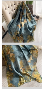 Detail of silk-like scarf with gold butterfly prints and smooth textile texture
