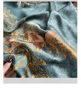 Detailed view of ocean wave printed silk scarf with golden edges and satin luster