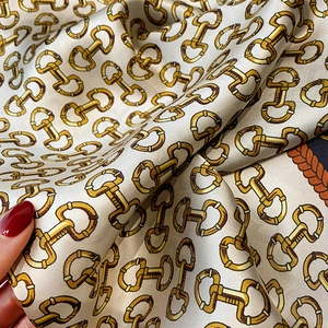 Macro detail of twill silk scarf showing horsebit pattern and smooth reflective texture
