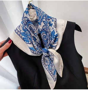 Close-up of floral silk scarf tied elegantly on a black dress with paisley pattern