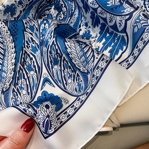 Detailed view of paisley floral silk scarf showing fine stitching and smooth satin texture