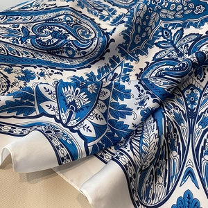 Detail of blue paisley silk scarf showing smooth texture and floral pattern close-up