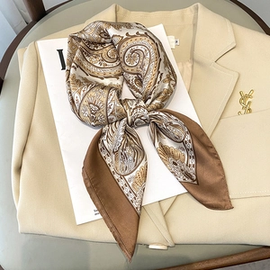 Elegant paisley floral silk scarf in coffee and beige draped over a suit jacket