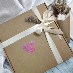 Pink holographic heart sticker on kraft gift box with lavender and white ribbon detail