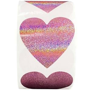 Macro shot of pink heart holographic laser stickers with iridescent rainbow finish on rolls