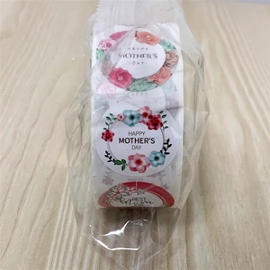 Macro shot of roll-packed Mother's Day floral stickers with Happy Mother's Day text