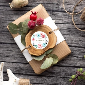 Close-up of floral Happy Mother's Day sticker on a rustic wooden tag for gift wrapping