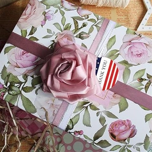 Detailed gift box featuring pink roses, satin ribbon, and a USA flag Thank You sticker