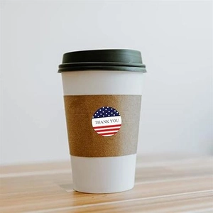 Close-up of American flag Thank You sticker on a corrugated coffee cup sleeve