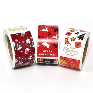 Macro view of three Christmas sticker rolls with snowmen, reindeer and festive patterns