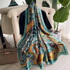 Retro paisley silk-like shawl scarf in teal and orange hanging on an armchair
