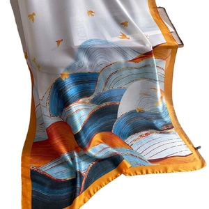 Silk-like scarf with ocean waves illustration and gold trim, draped as a beach shawl