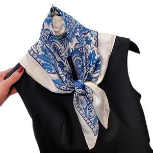 Elegant blue and white floral paisley silk scarf tied on a black sleeveless top neckline