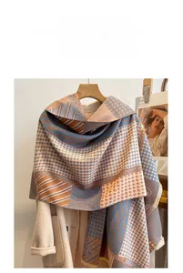 Detail of cashmere-like houndstooth scarf with blue and orange geometric patterns