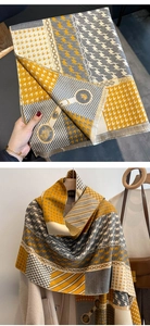 Detail of cashmere-like scarf showing houndstooth patterns and yellow-grey tassels