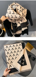 Detail of beige and black knit scarf with V-shape patterns and delicate fringed edges