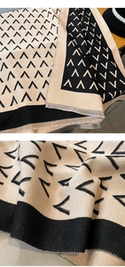 Close-up of knit scarf with geometric arrow patterns and soft fringe detail texture