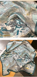 Detailed close-up of blue silk scarf featuring traditional Chinese landscape painting patterns