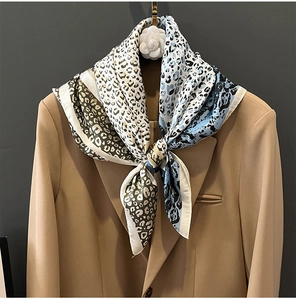 Detailansicht eines Seidenschals mit Leopardenmuster kombiniert mit einem Khaki-Blazer