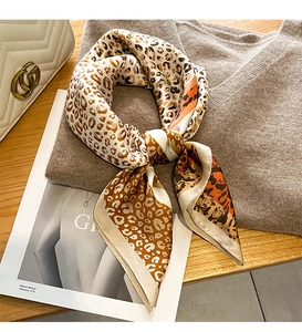 Nahaufnahme eines Satin-Halstuchs mit Leopardenmuster und orangefarbenem Rand-Design