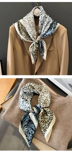 Nahaufnahme des Seidenschals mit Leopardenmuster, glatter Textur und feiner Rollsaumkante