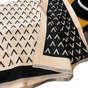 Double-sided champagne gold and black scarf with geometric V-pattern and fringe trim