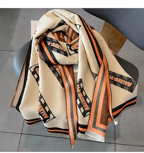 Détail de l'écharpe en imitation cachemire beige avec bordure orange et franges