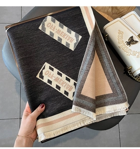 Détail d'une écharpe à lettres double face avec franges et design patchwork bicolore