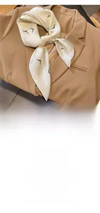 Detail of silk-like neck scarf with bird pattern styled with a camel blazer