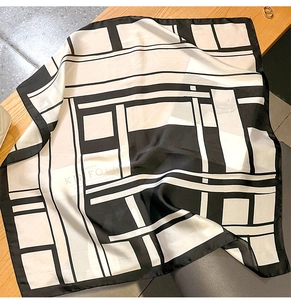 Close-up of black and white geometric silk scarf draped on a chair in a home setting