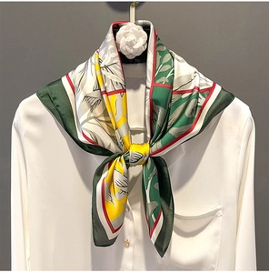 Detail of printed silk scarf tied on white shirt showing retro floral patterns
